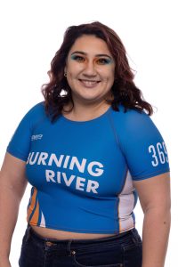 Sari smiles at the camera wearing a Burning River jersey